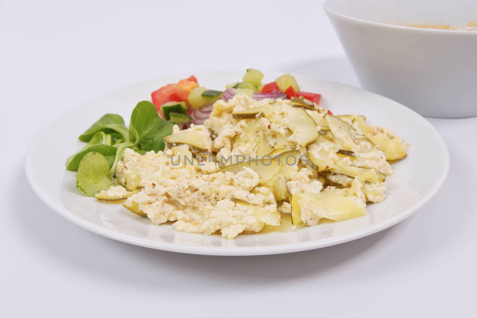 Baked zucchini vegetable salad on a white background