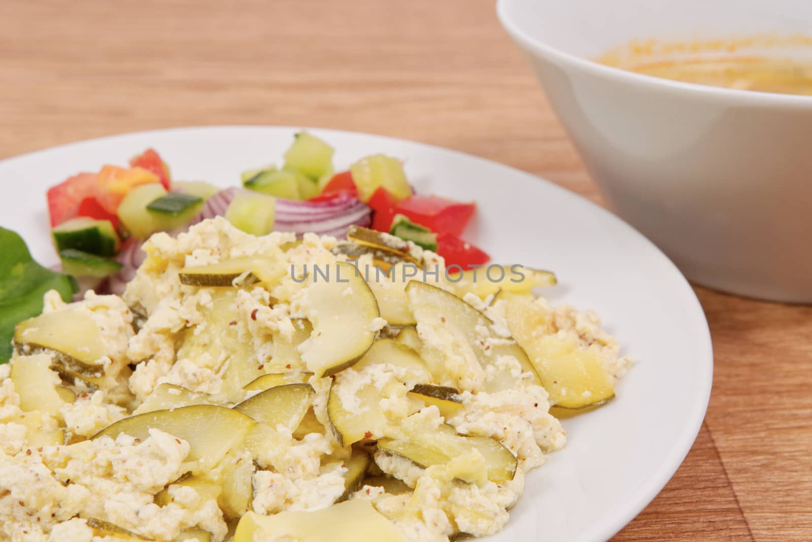 Baked zucchini vegetable salad on a white background