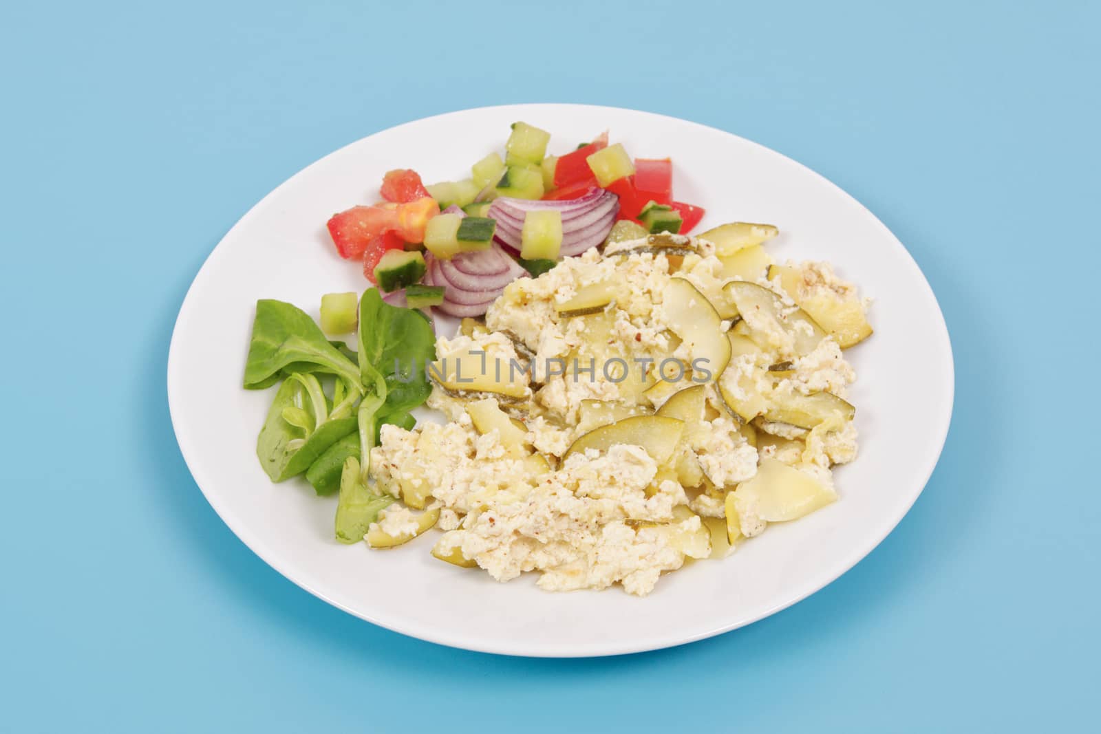 Baked zucchini vegetable salad on a white background