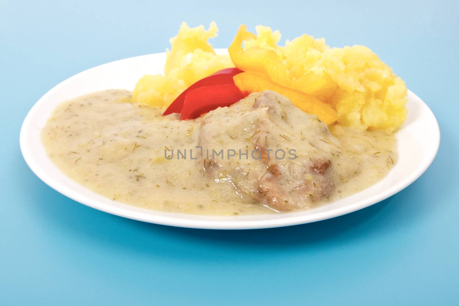 Seitan with dill sauce and potatoes on a blue background