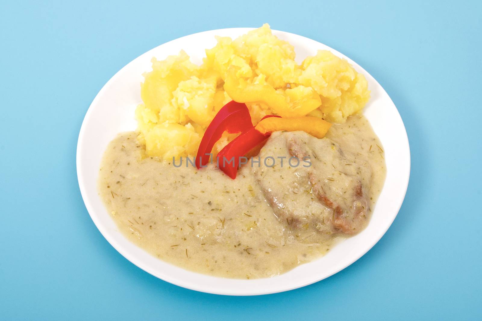 Seitan with dill sauce and potatoes on a blue background