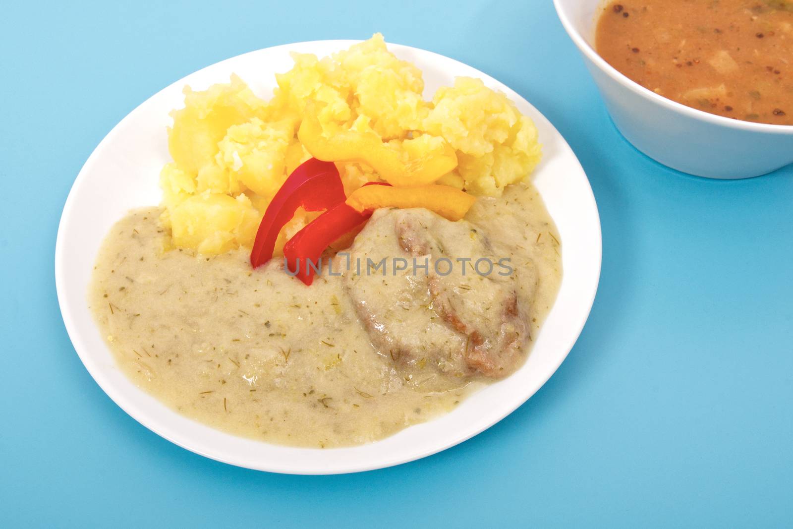 Seitan with dill sauce and potatoes on a blue background