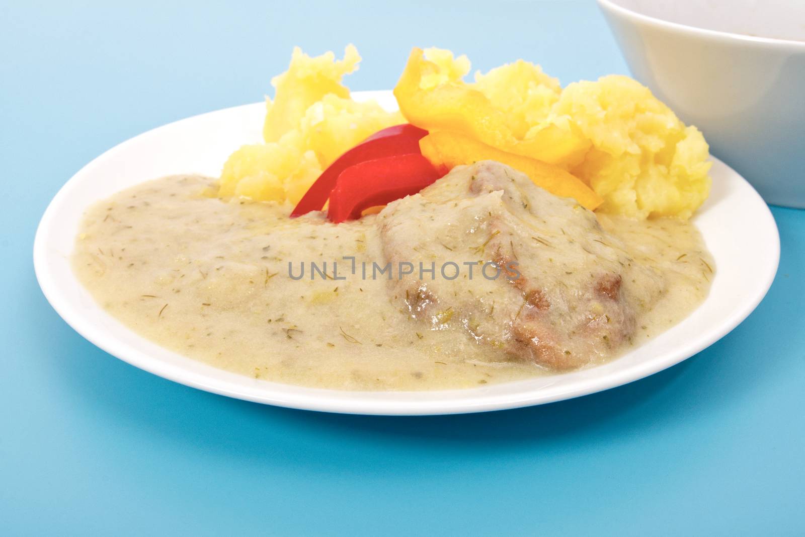 Seitan with dill sauce and potatoes on a blue background