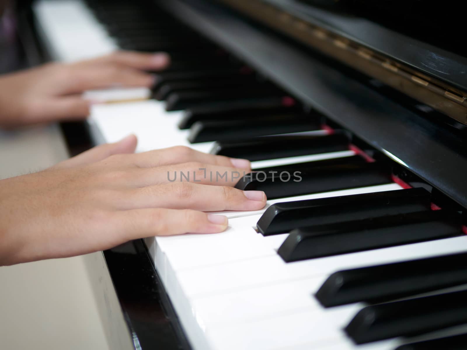 Close up of child hand on piano keys playing