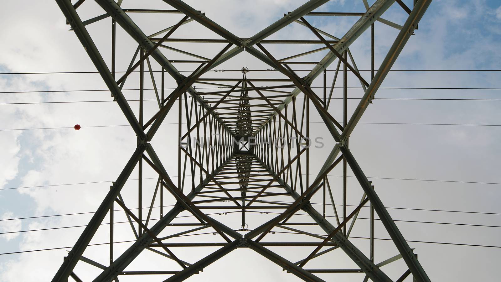 electric high voltage column with wires on the sky background