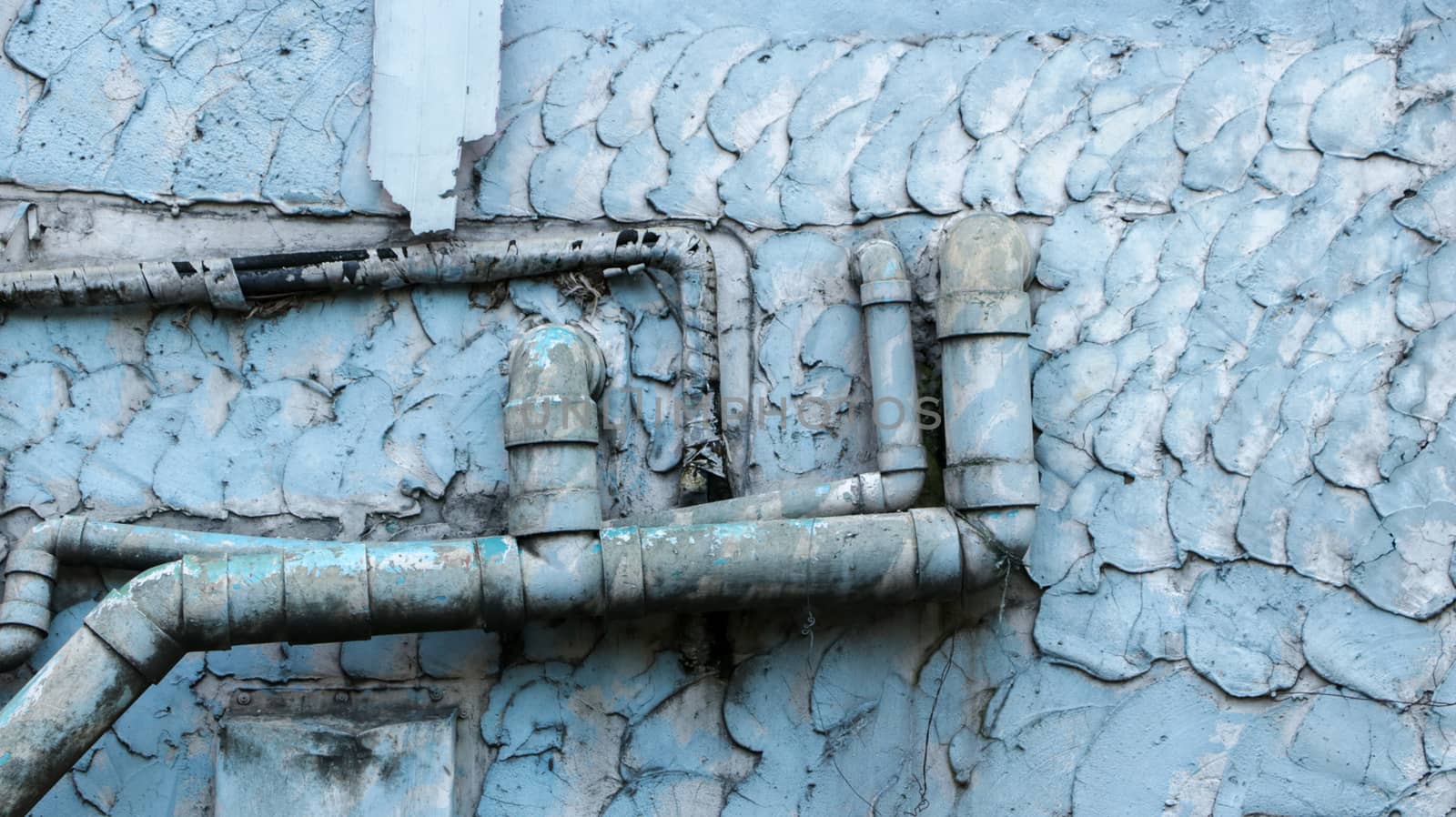 Old Dirty Water Pipes on Vintage Painted Wall Texture - Blue/ Teal Pastel. Outside local house in the countryside Thailand.