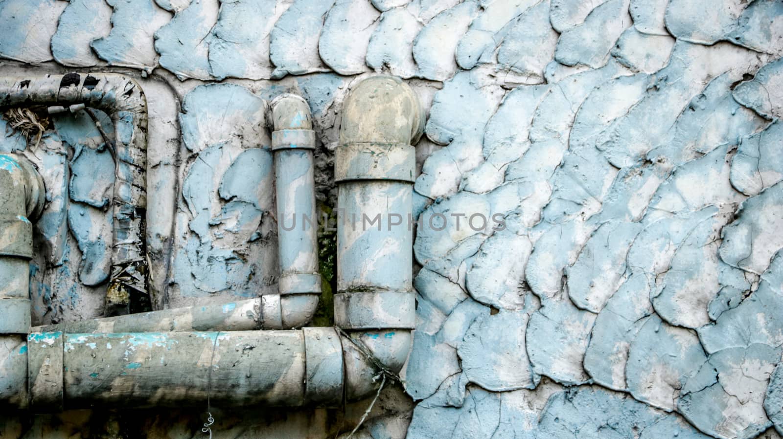 Old Dirty Water Pipes on Vintage Painted Wall Texture - Blue/ Teal Pastel. Outside local house in the countryside Thailand.