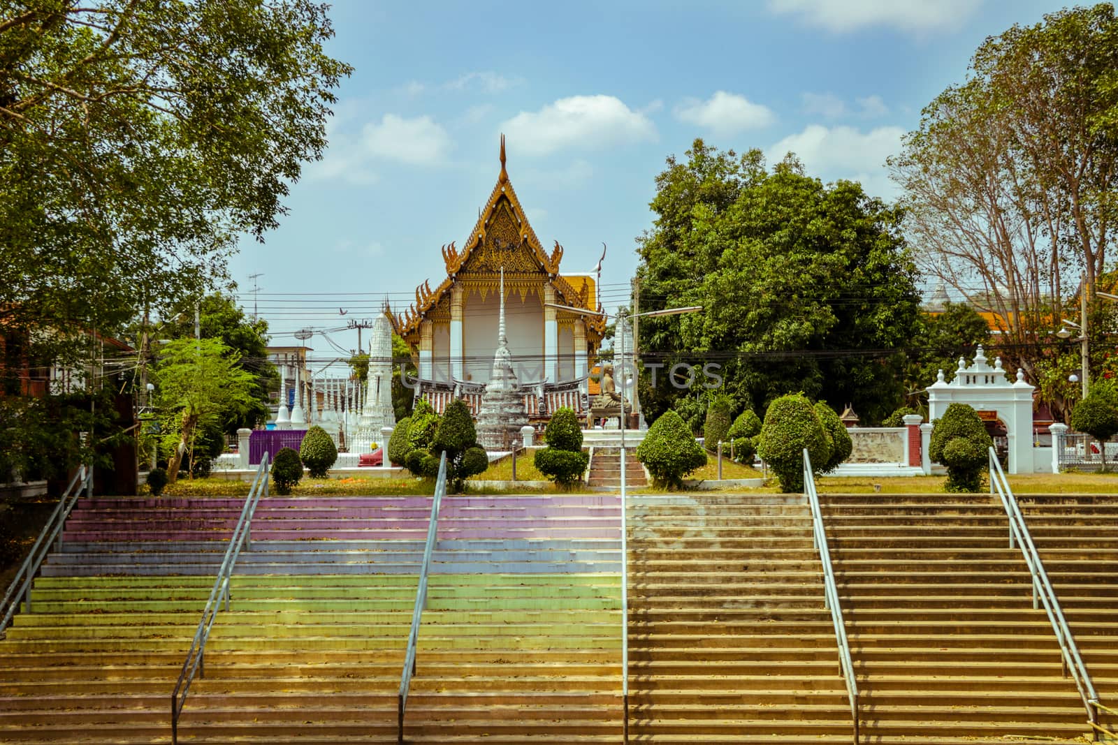 Riverside Buddhist Temple with Vintage Colorful Stairs in Phetchaburi, Thailand. Rural Area with Green Tree. Sunny Day. Vivid Colors.