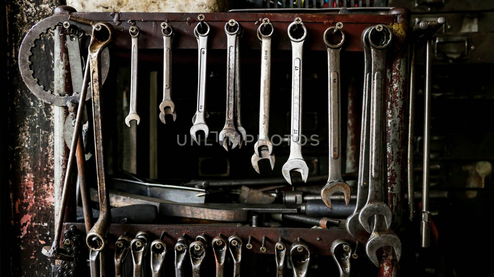 Set of Dirty Wrenches/ Spanners on Wooden Shelf with Different Tools in Garage. Motorbike Repair Shop in  Thailand.