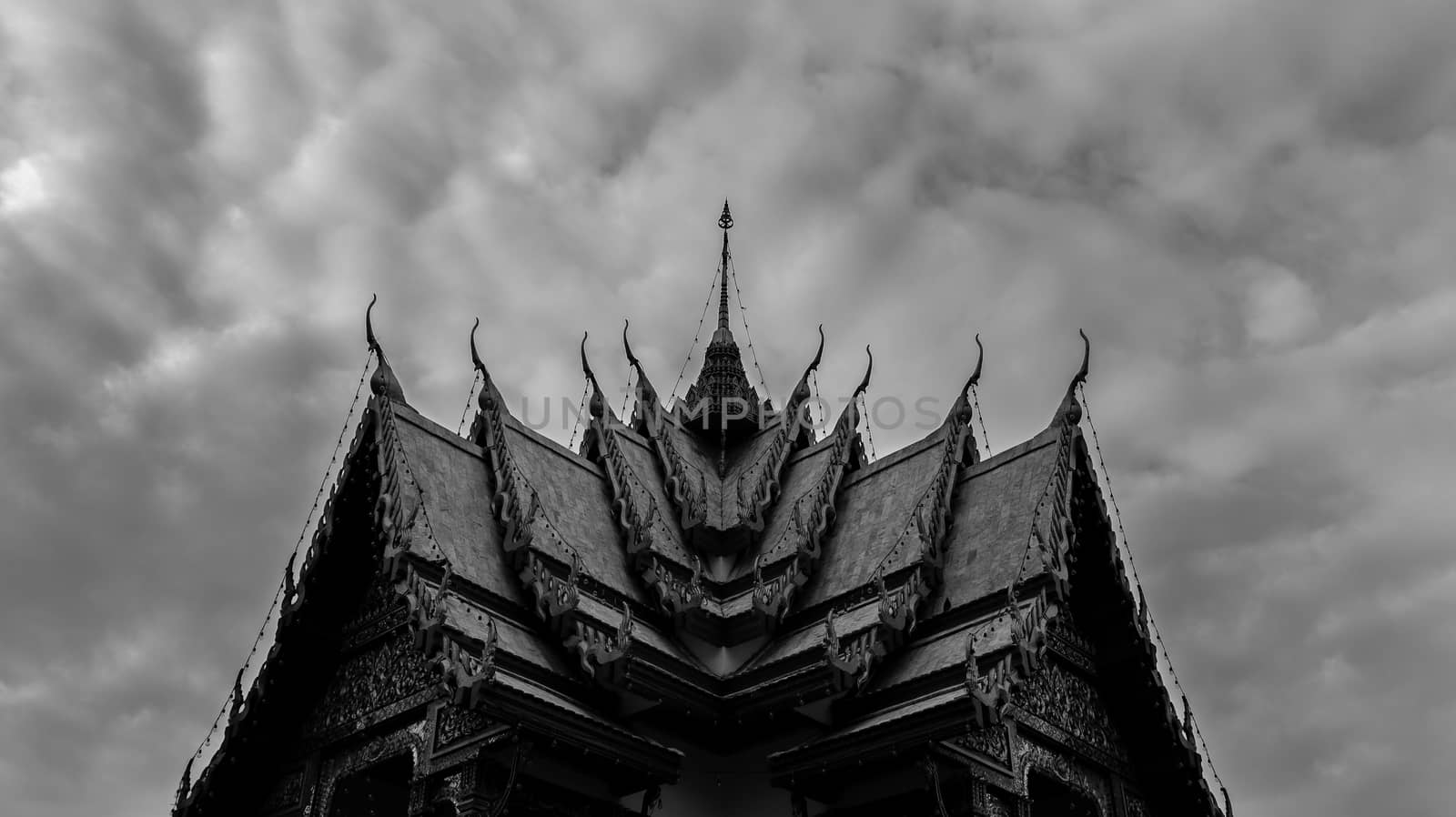 Monochromatic Symmetrical Buddhist Temple Roof in Bangkok Thailand with Beautiful Patterns. Cloudy Sky. High Contrast.