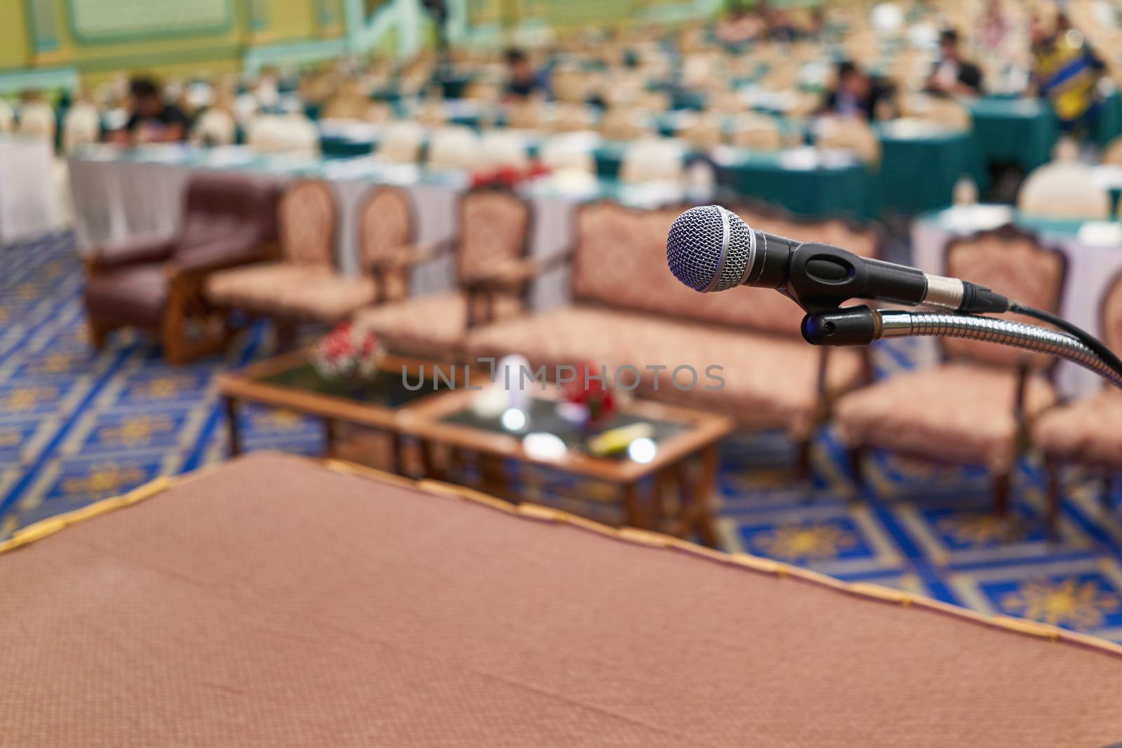 Close up microphone on table have blur vip seats and participant in conference room as background. Business and seminar concept successful.