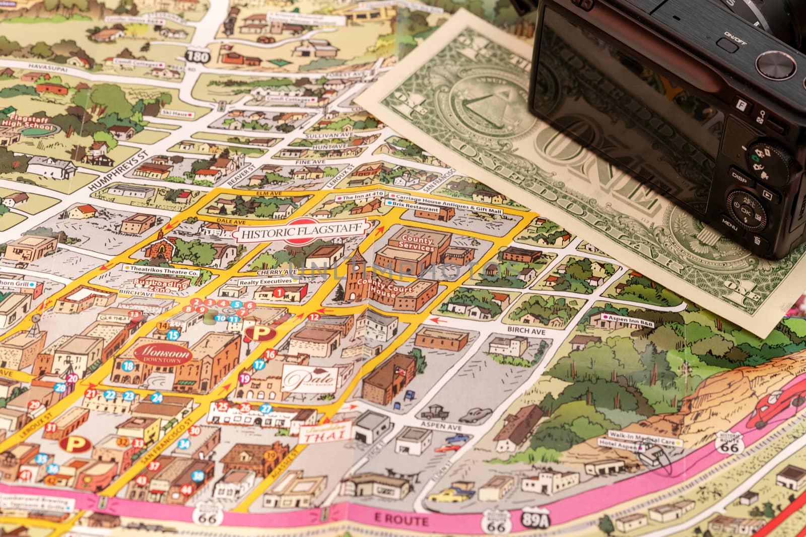 Detail of travel map Flagstaff, Arizona, USA with camera and one Dollar bill, travel planning and preparation concept