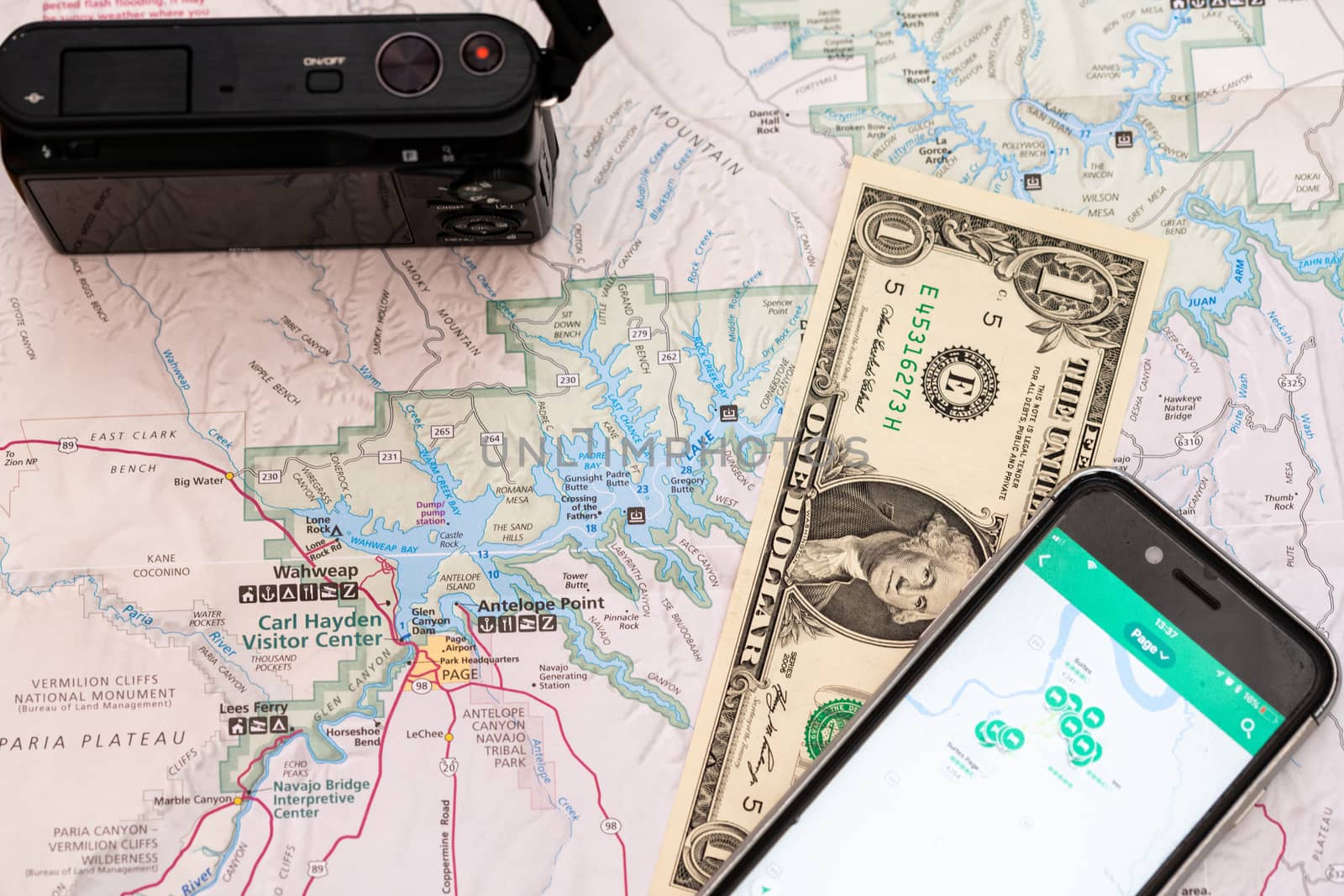 Travel accessories, camera, smart phone one Dollar bill and travel map, detail of Arizona, USA map, travel preparation and planning concept to Lake Powell area