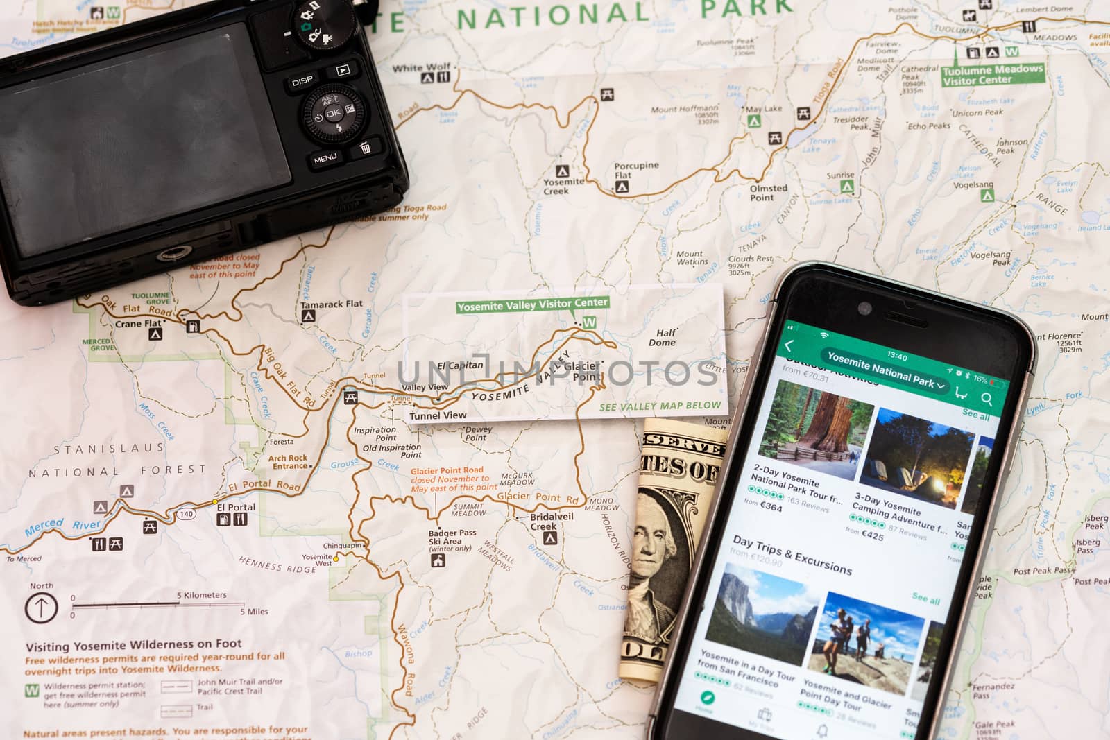 Travel accessories, camera, smart phone, folded one Dollar bill and travel map, detail of Arizona, USA map, travel preparation and planning concept to Lake Powell area