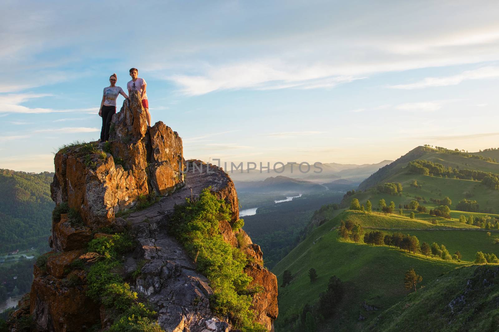 Happy man and woman on top mountain by rusak