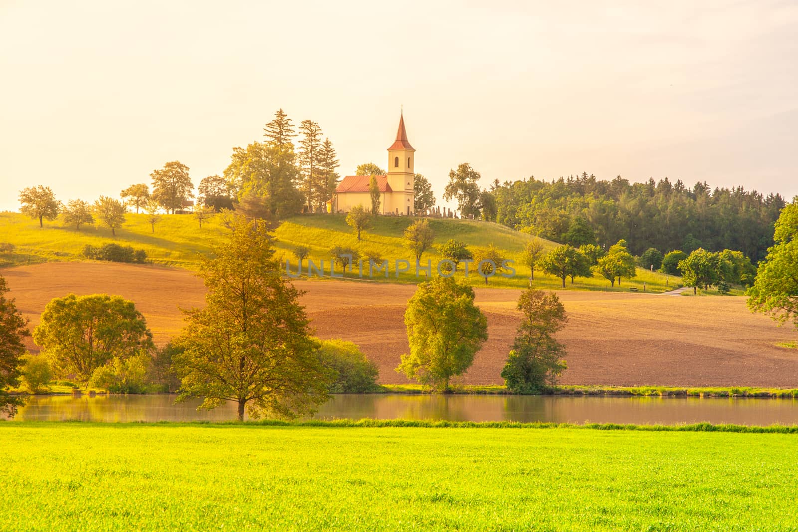 Small church in the middle of lush green spring landscape on sunny day. St. Peter and Pauls church at Bysicky near Lazne Belohrad, Czech Republic by pyty