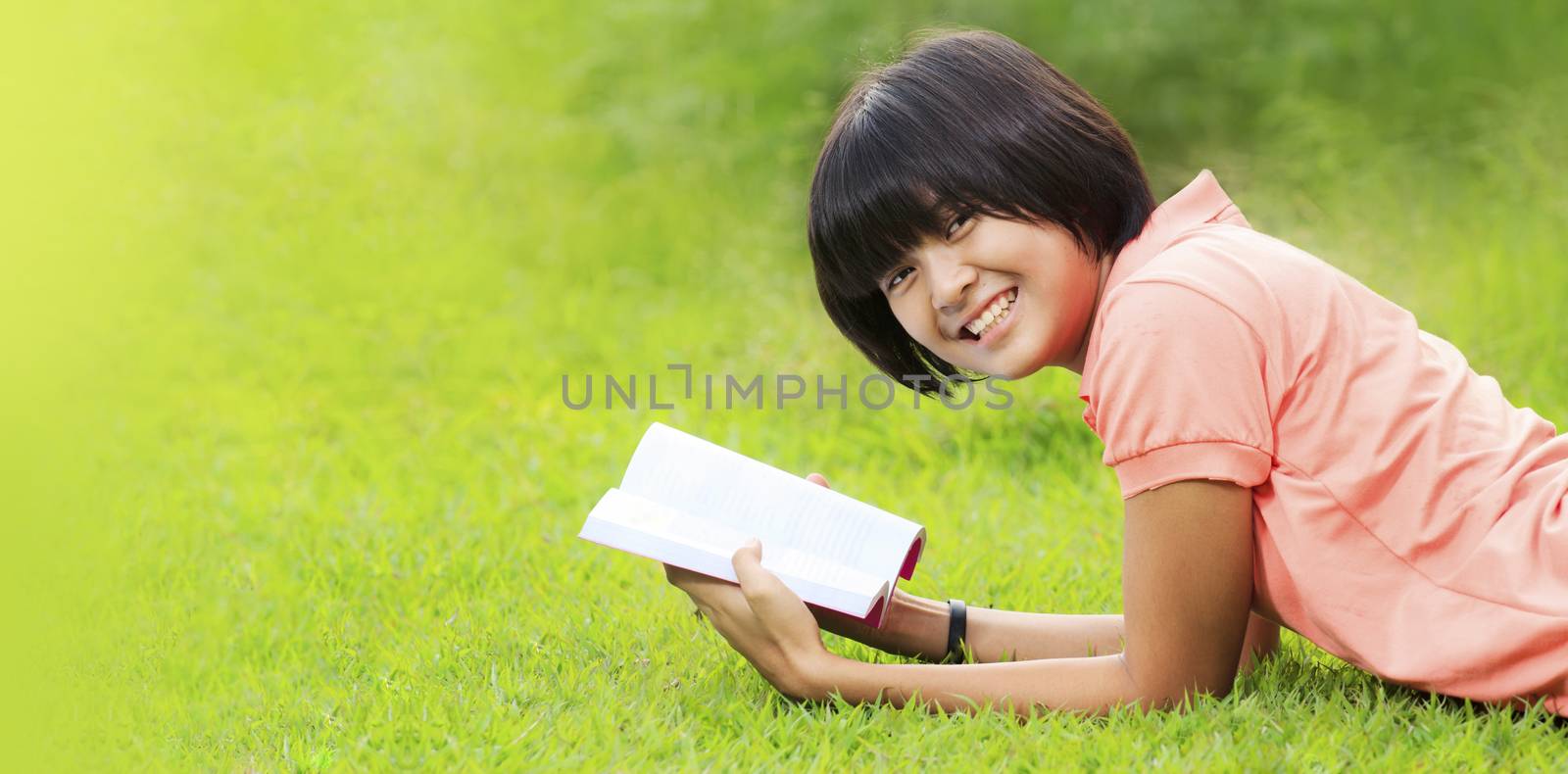 Asian girl reading a book in a park