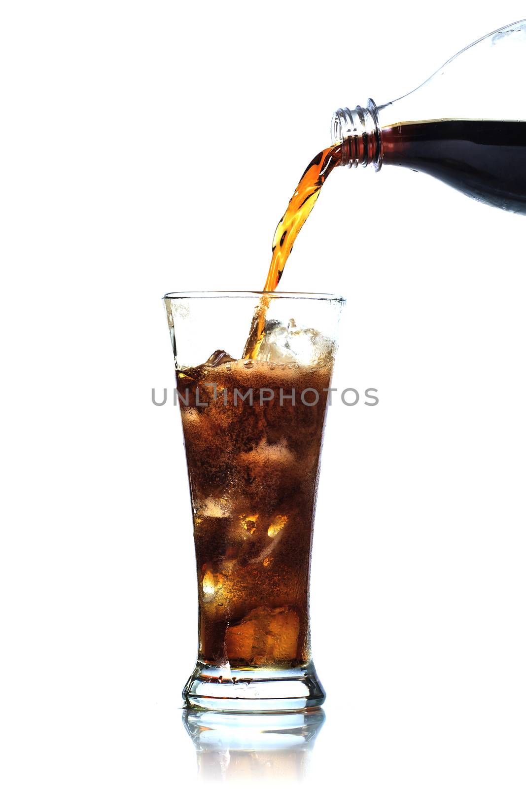 Cola is pouring into glass on white background