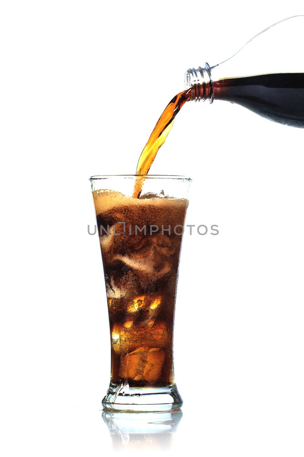 Cola is pouring into glass on white background