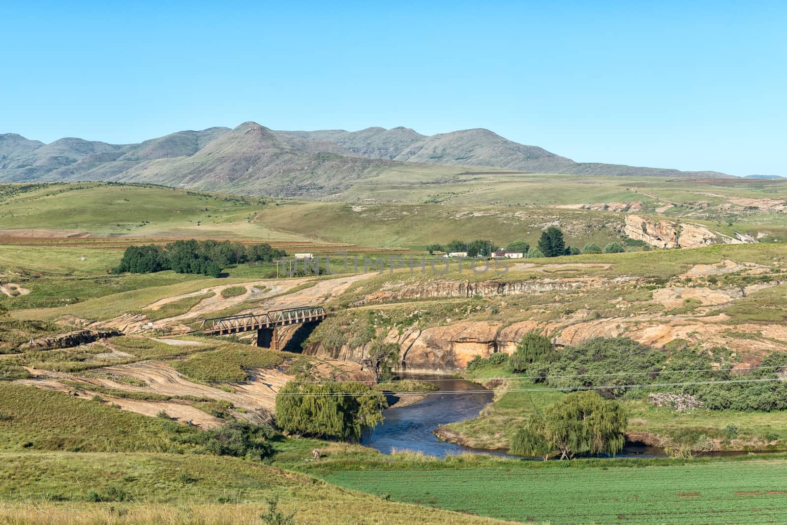 A farm landscape with a single lane bridge on road R396 over the Bell River near Rhodes in the Eastern Cape Province of South Africa