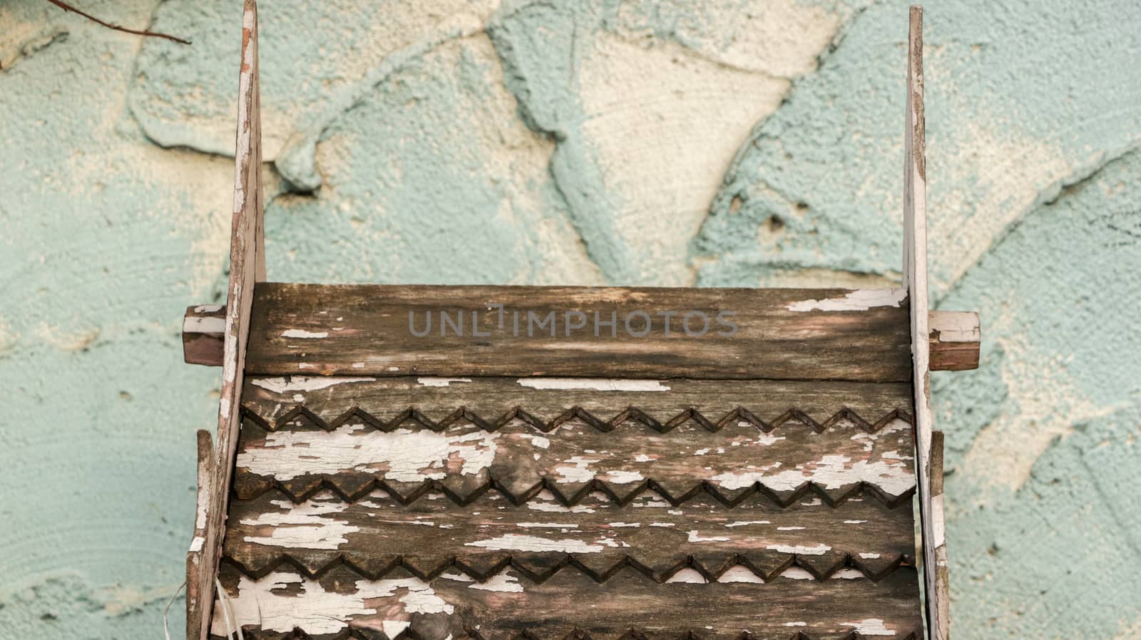 Wooden Roof Pattern with Rough Painted Teal/ Blue Wall - Miniature Wood Temple/ Spirit House in front of Local Home. Rural Thailand.