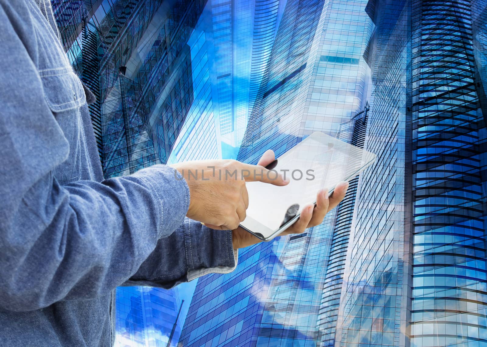 Businessman using digital tablet with modern building 