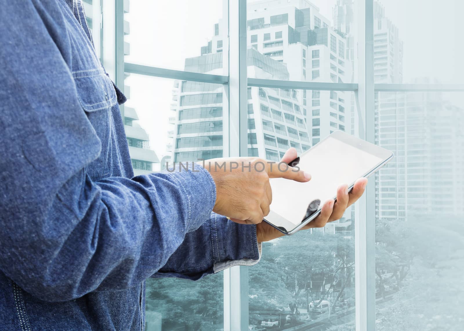 Businessman using digital tablet with modern building 