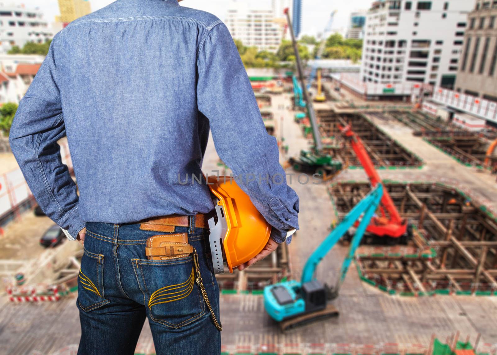 Cropped view of construction worker with orange helmets at workplace on construction site