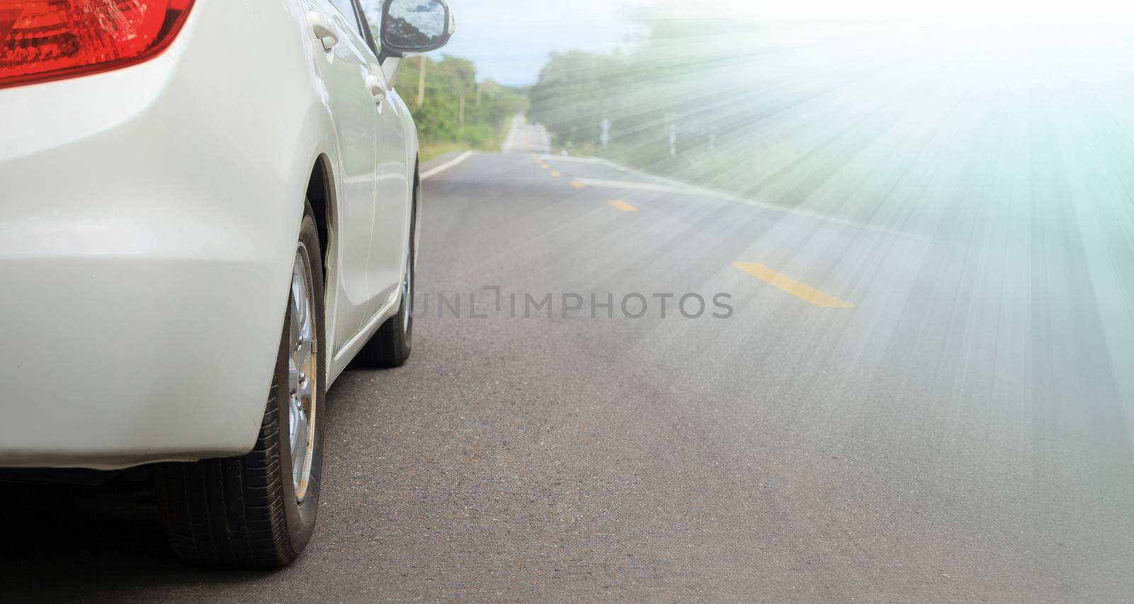 Close up side of white car and light on asphalt road