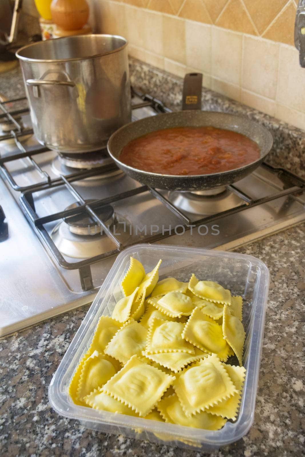 preparing ravioli with tomato sauce on a stovetop