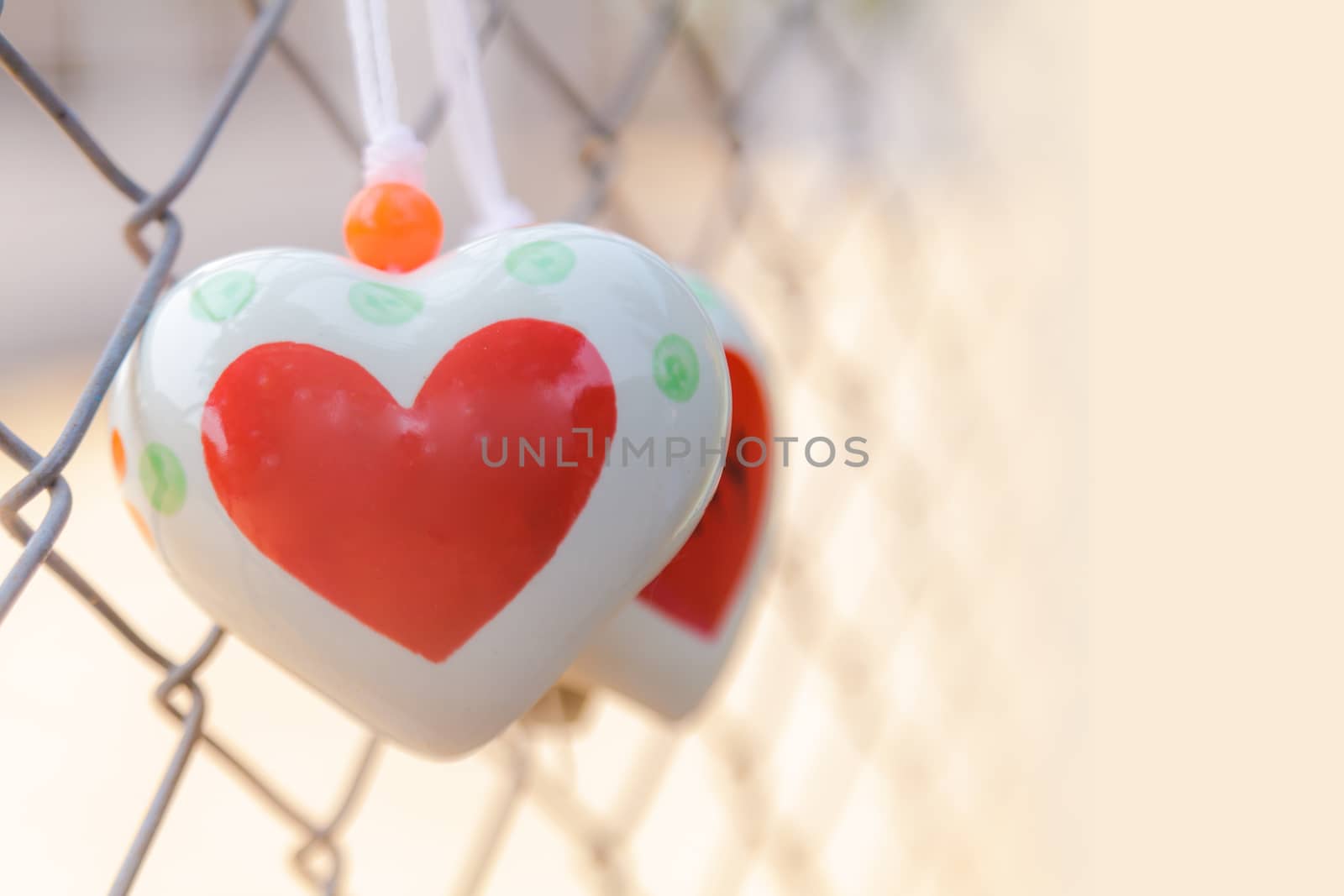 Heart toys on the cage metal net background