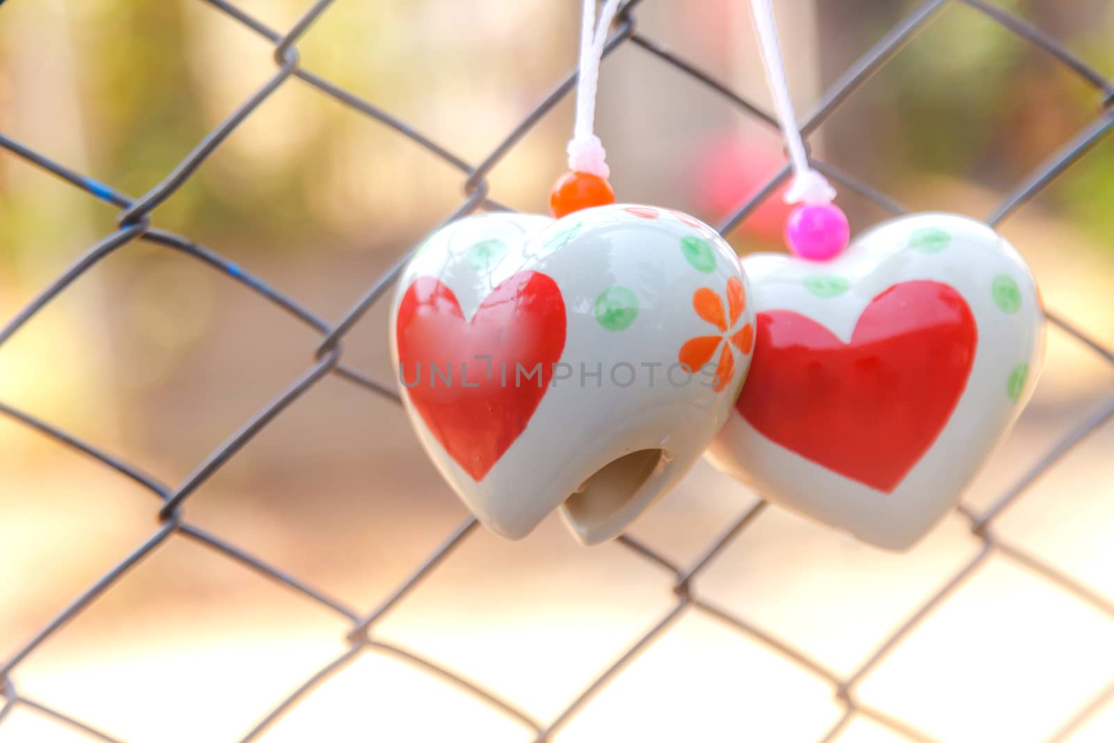 Heart toys on the cage metal net background