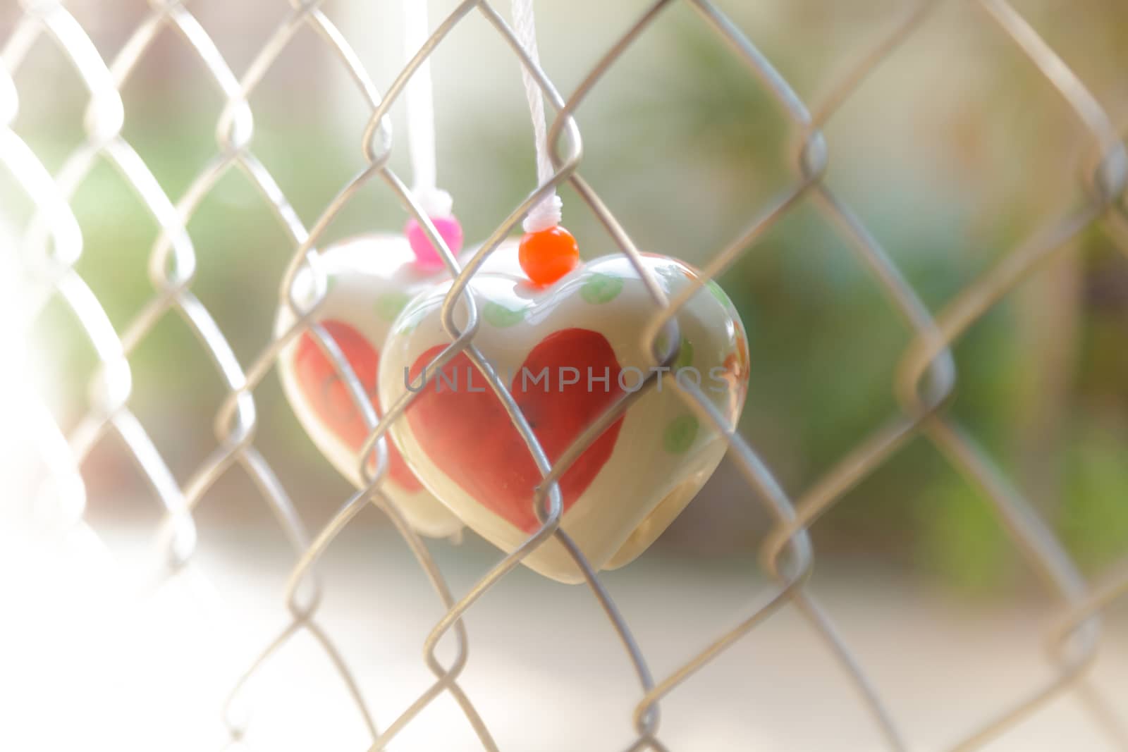 Heart toys on the cage metal net background