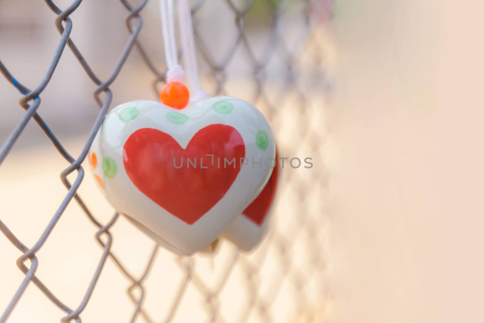 Heart toys on the cage metal net background