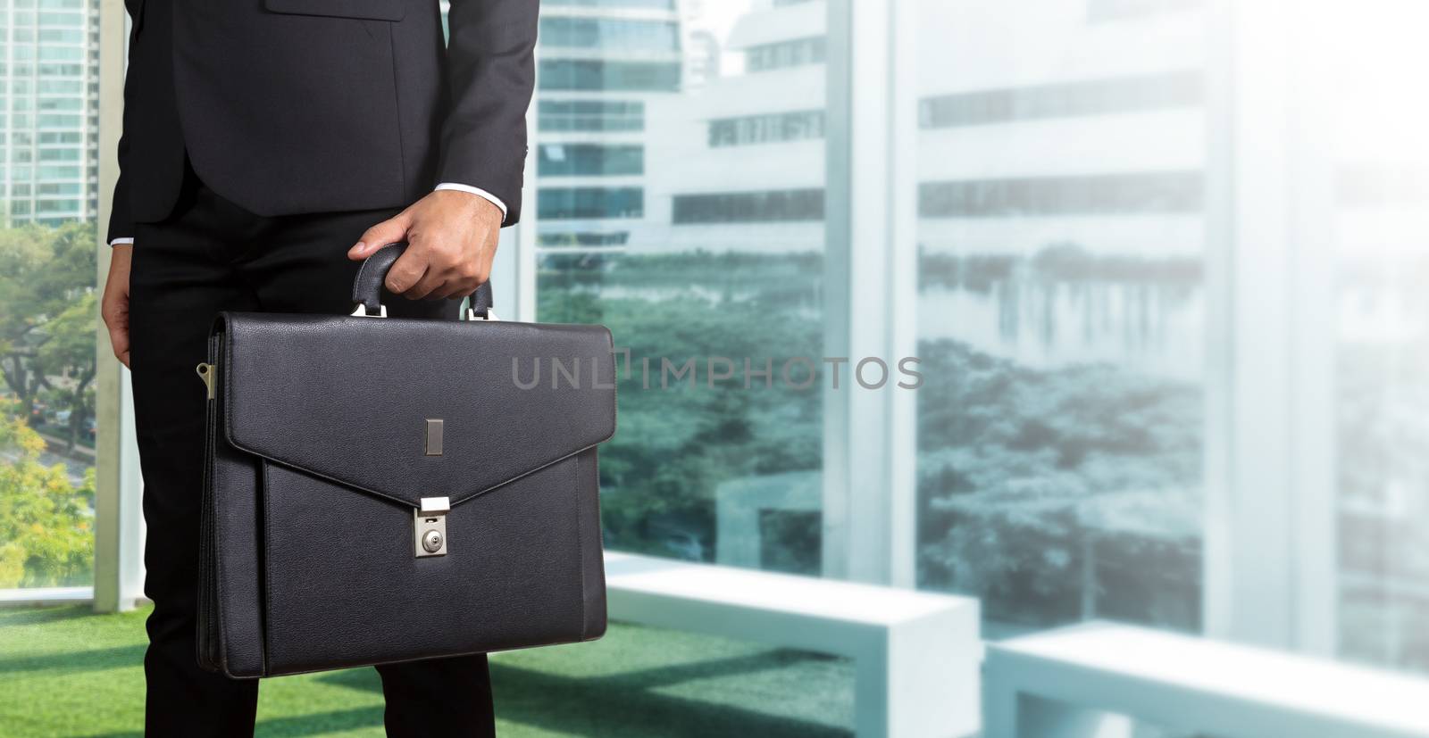 Businessman holding a briefcase in a modern office