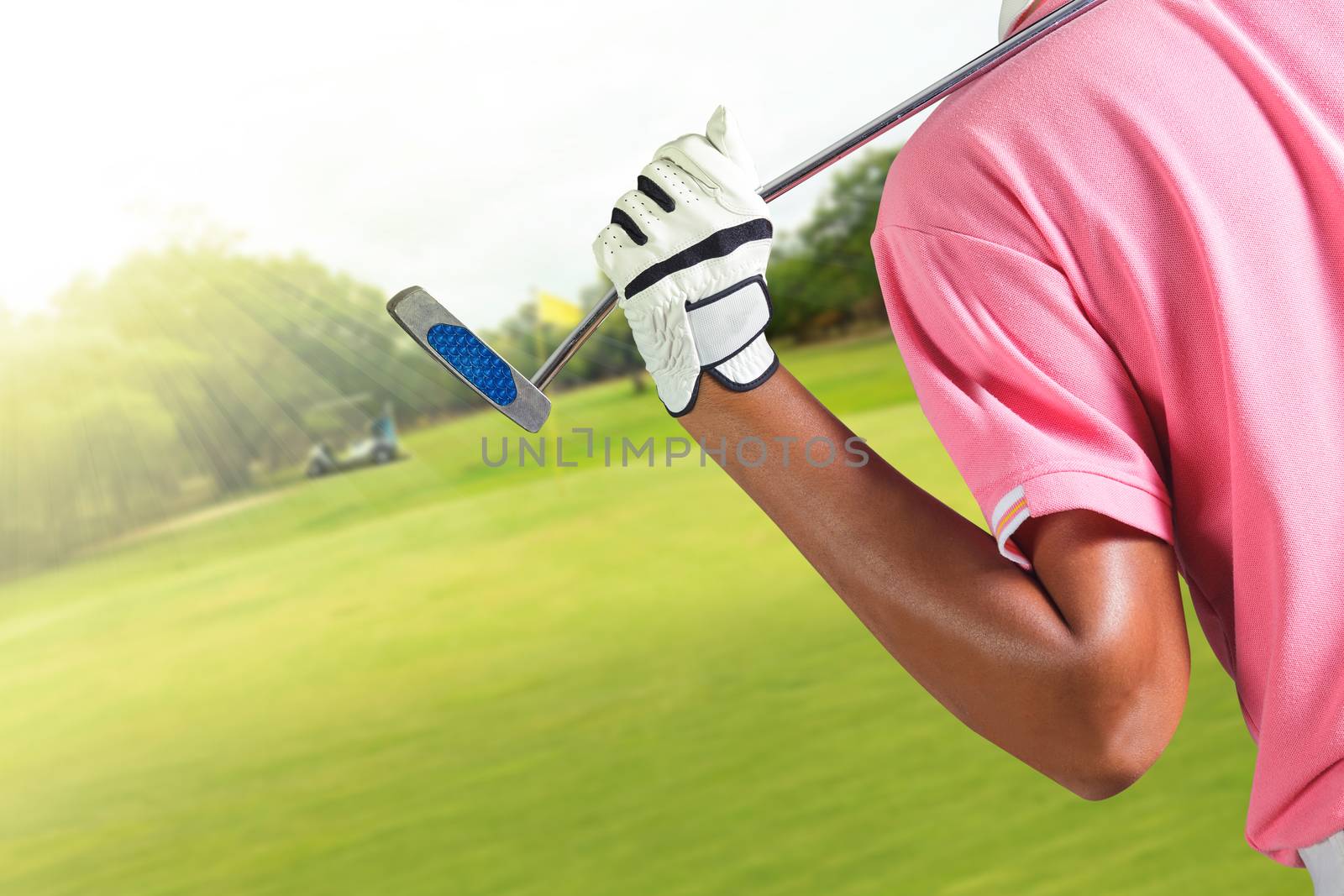 Golf player holding a golf club in golf course by Naypong
