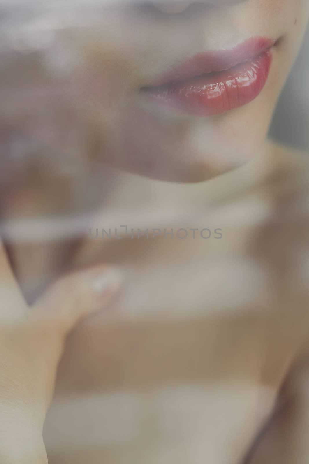 Crop view through glass of anonymous young woman with naked chest