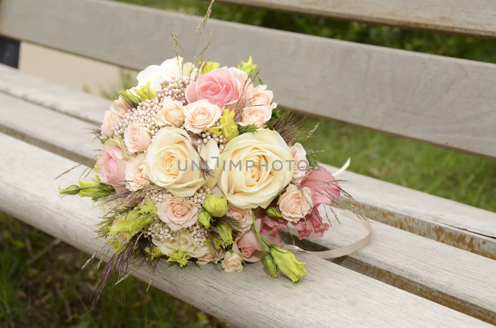 bouquet of wedding flowers lying on a wooden bench