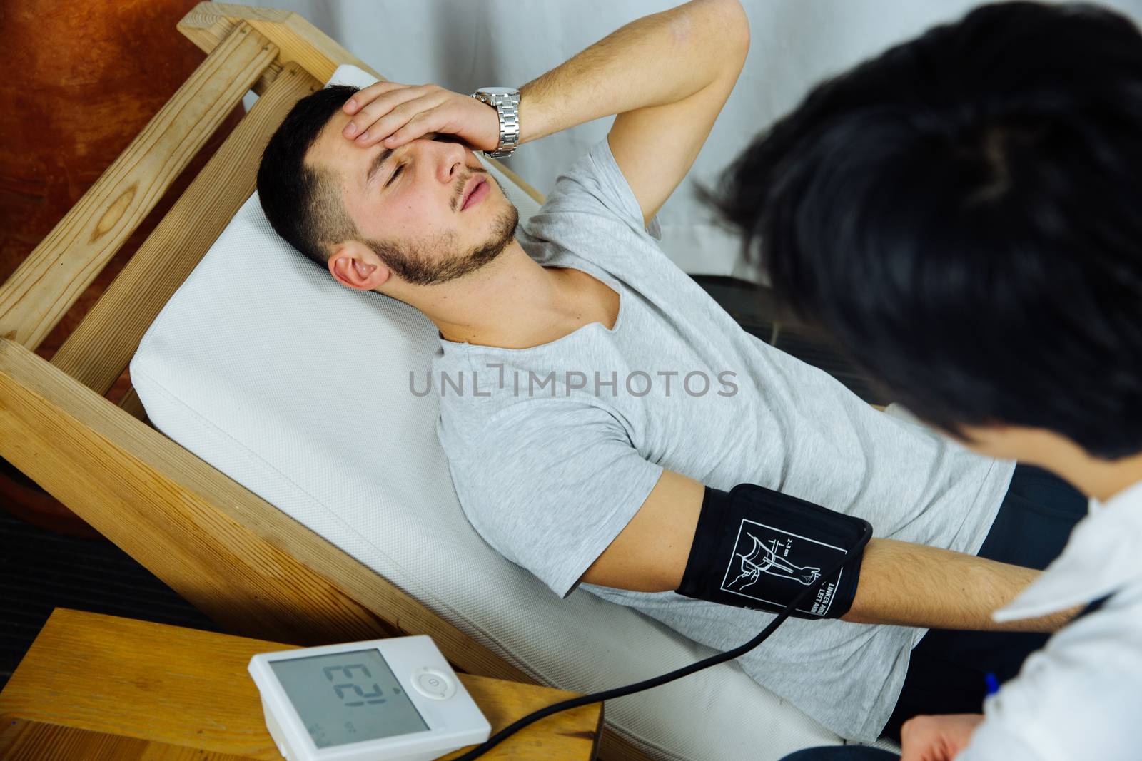 View of an caucasian nurse taking the blood pressure of a male patient