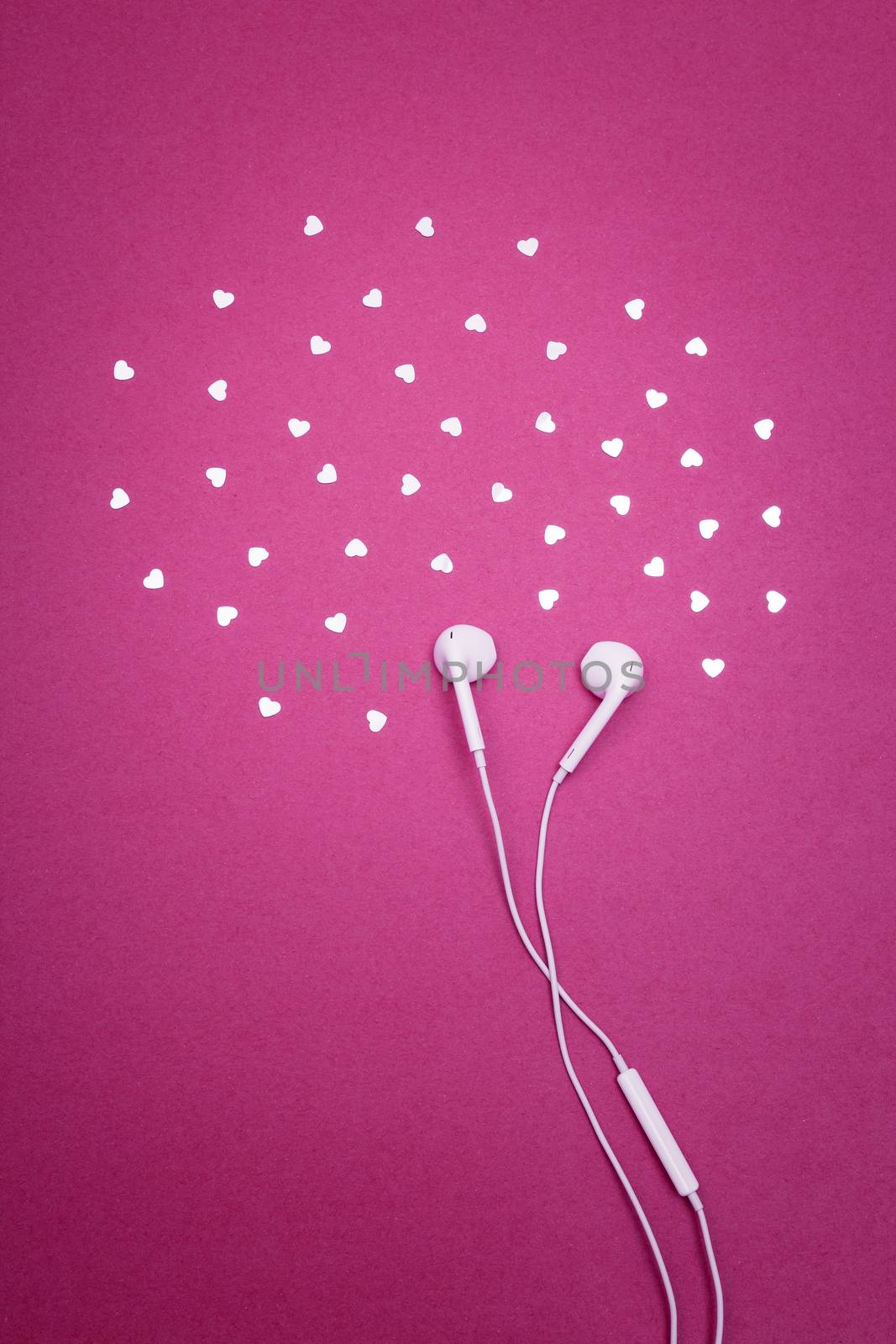 Earphones and hearts on bright magenta background by anikasalsera