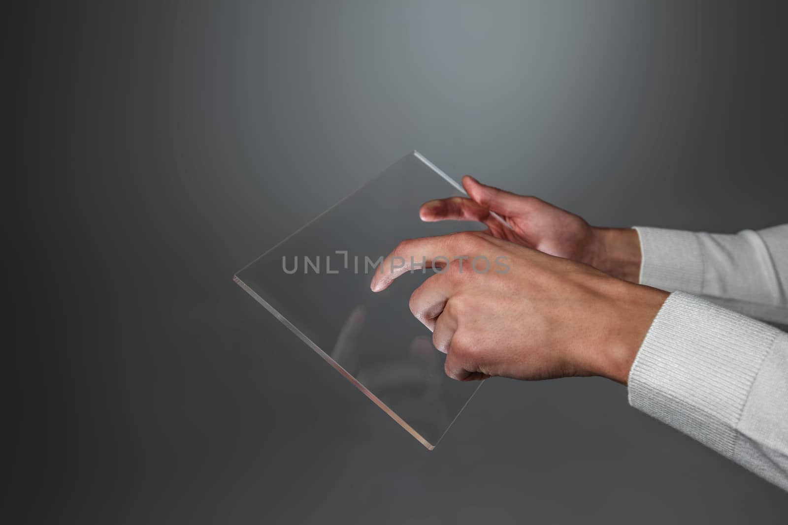 Male hands holding blank futuristic transparent digital tablet pc computer with copy space