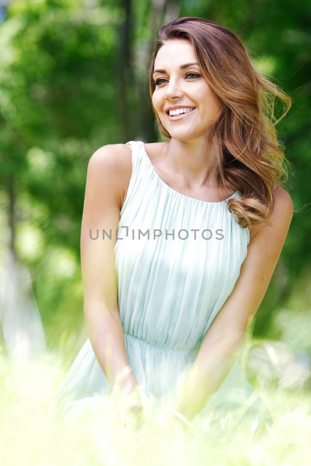 young woman in blue dress sitting on grass by Yellowj