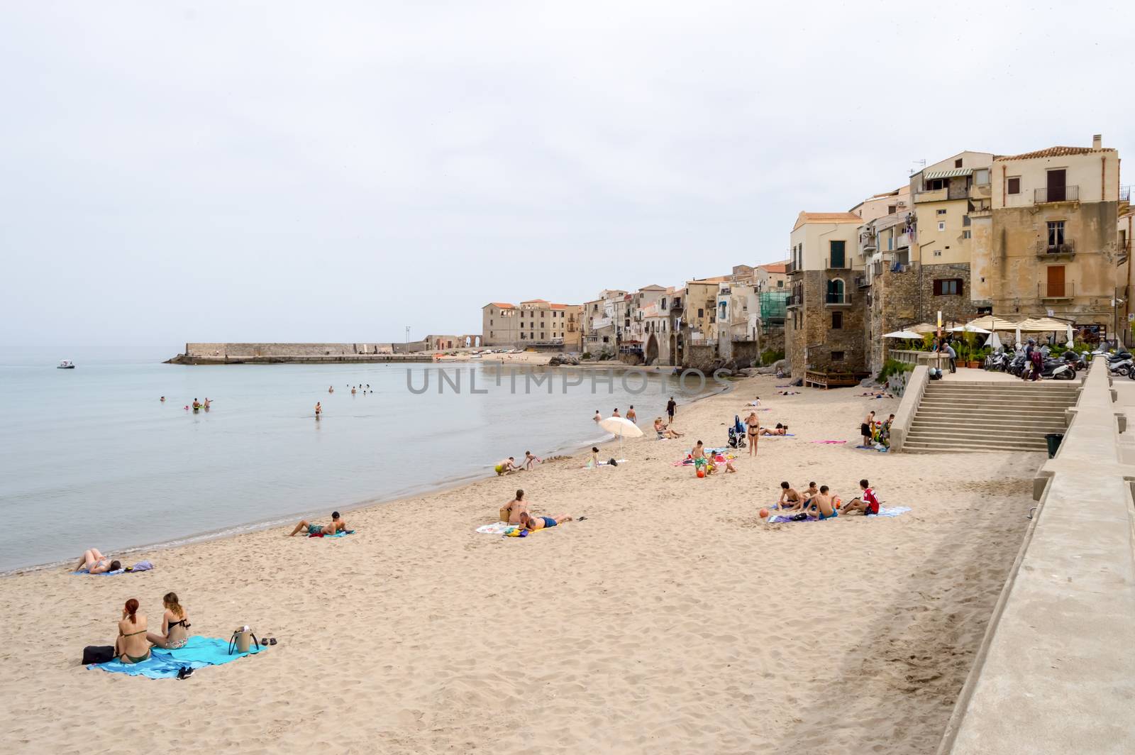 View of the beach of Cefalu with the old city in the background in the north of Sicily in Italy