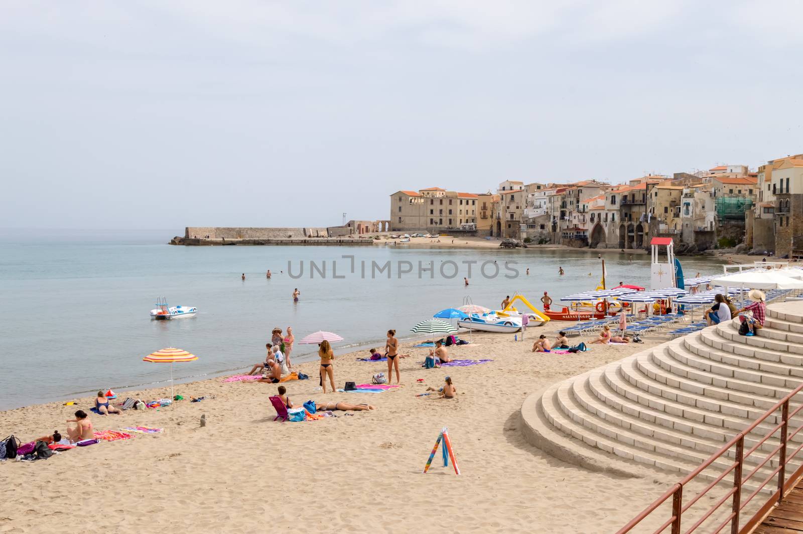 View of the beach of Cefalu with the old city in the background in the north of Sicily in Italy