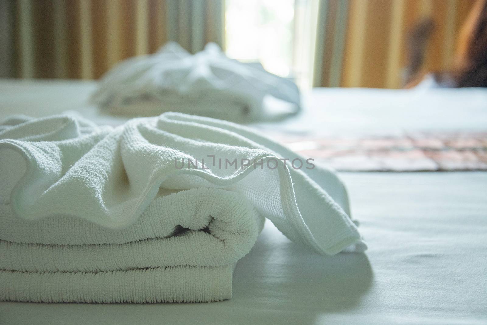 white towels on the bed with light from window. by rakoptonLPN