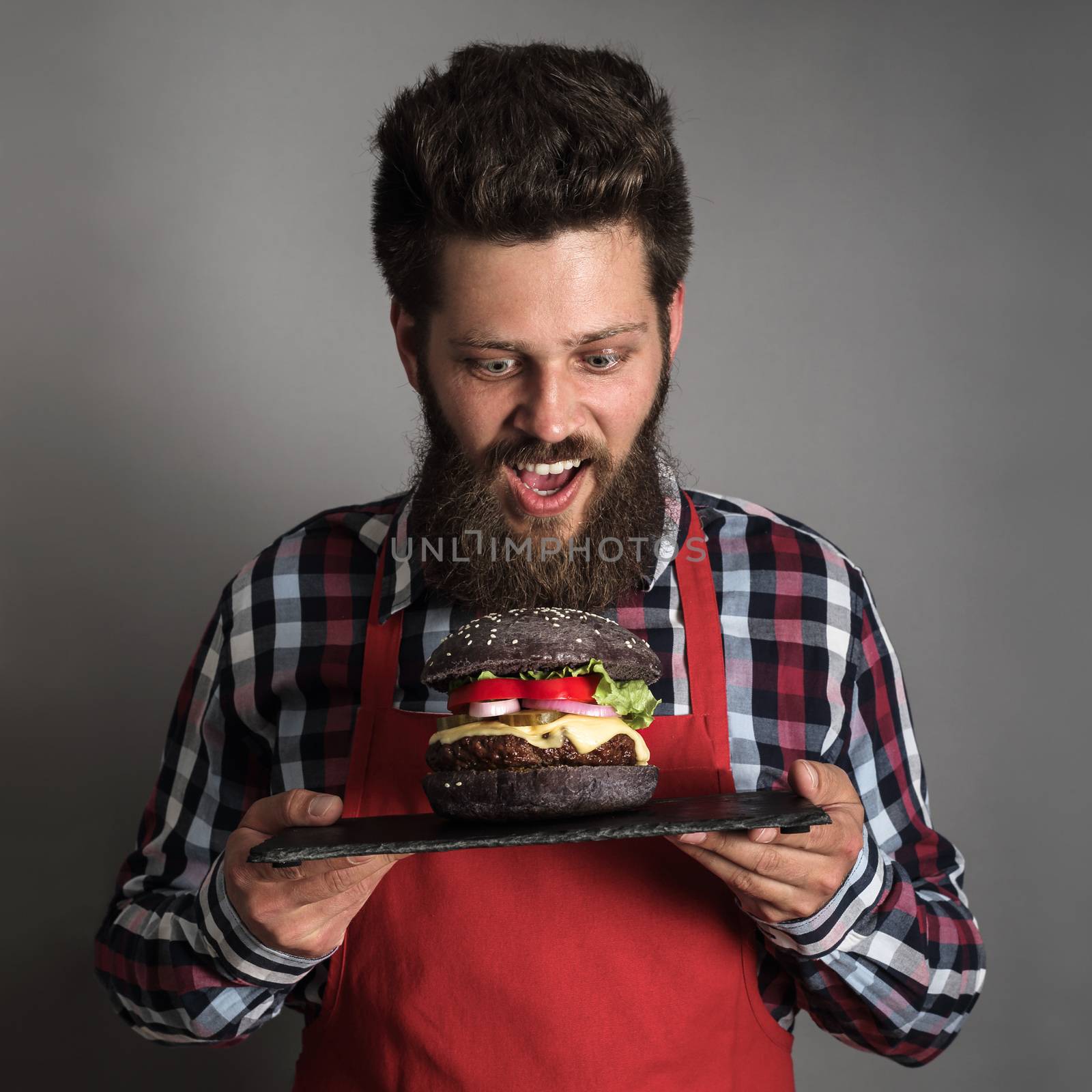 Man looking at fresh self made black burger close up