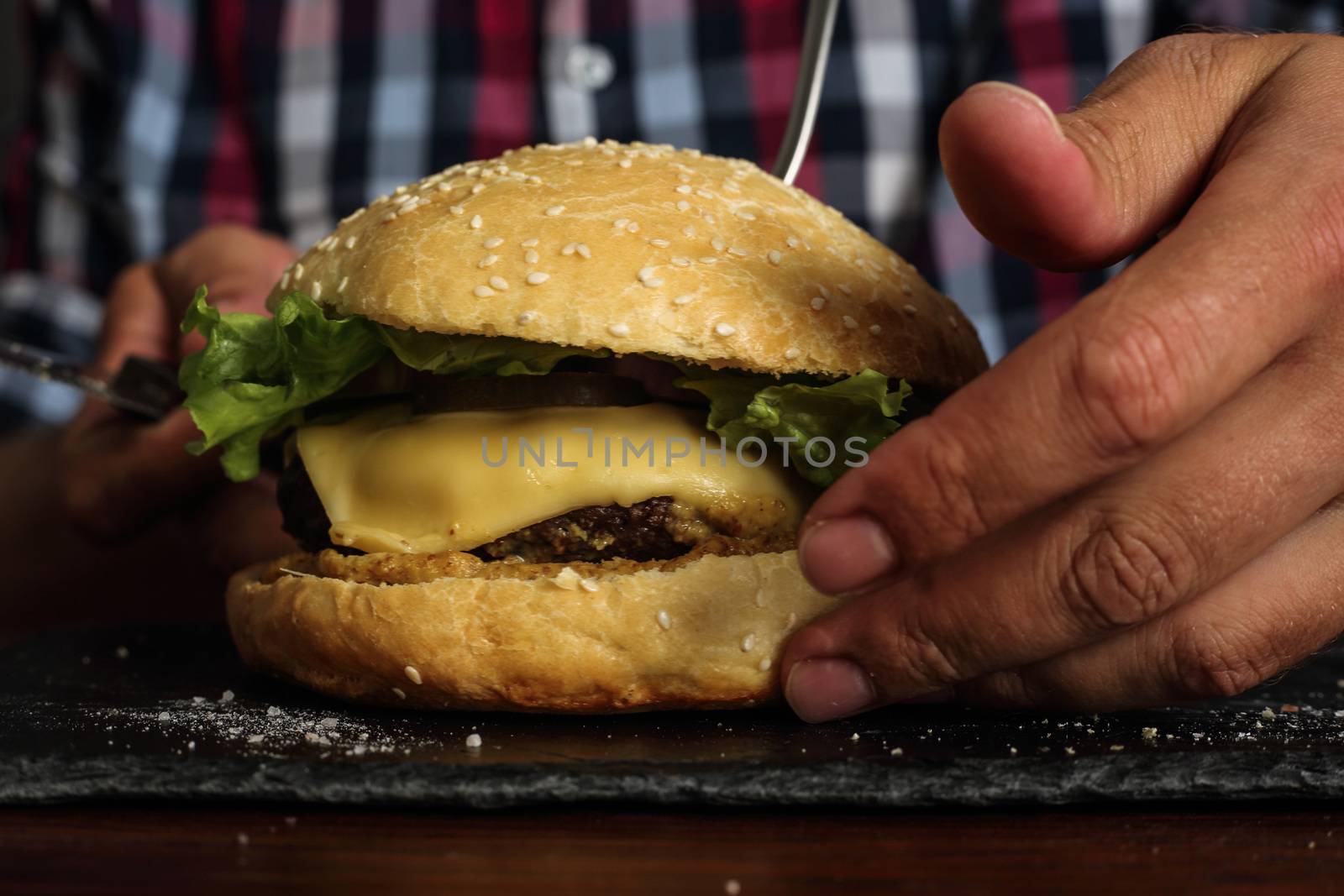 Man eating burger by destillat