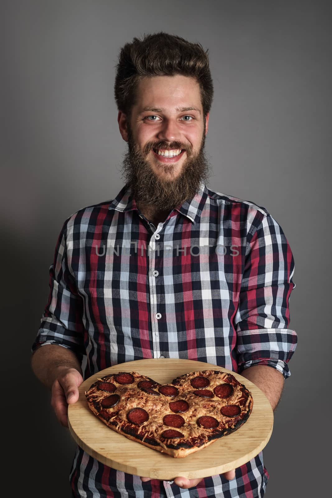 Man gives heart shapes pizza by destillat