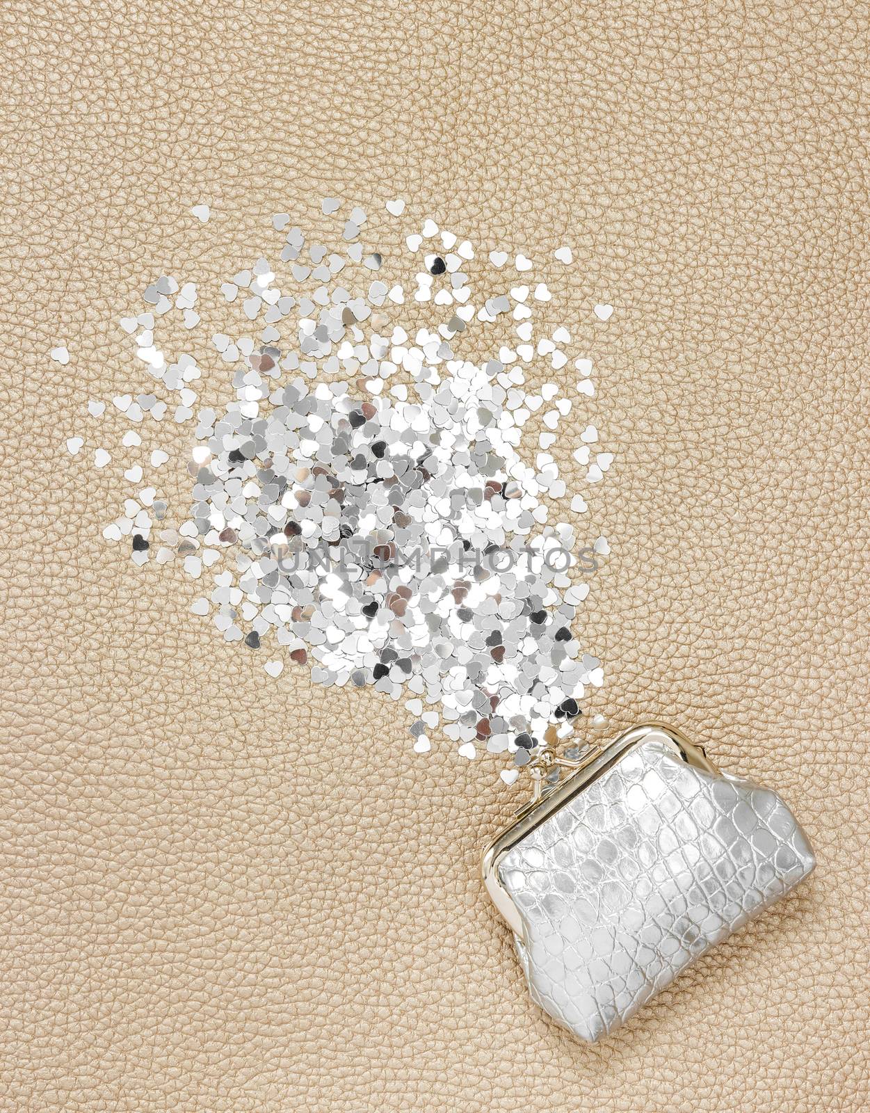 Silver purse and glitter hearts on leather background. Wealth concept.