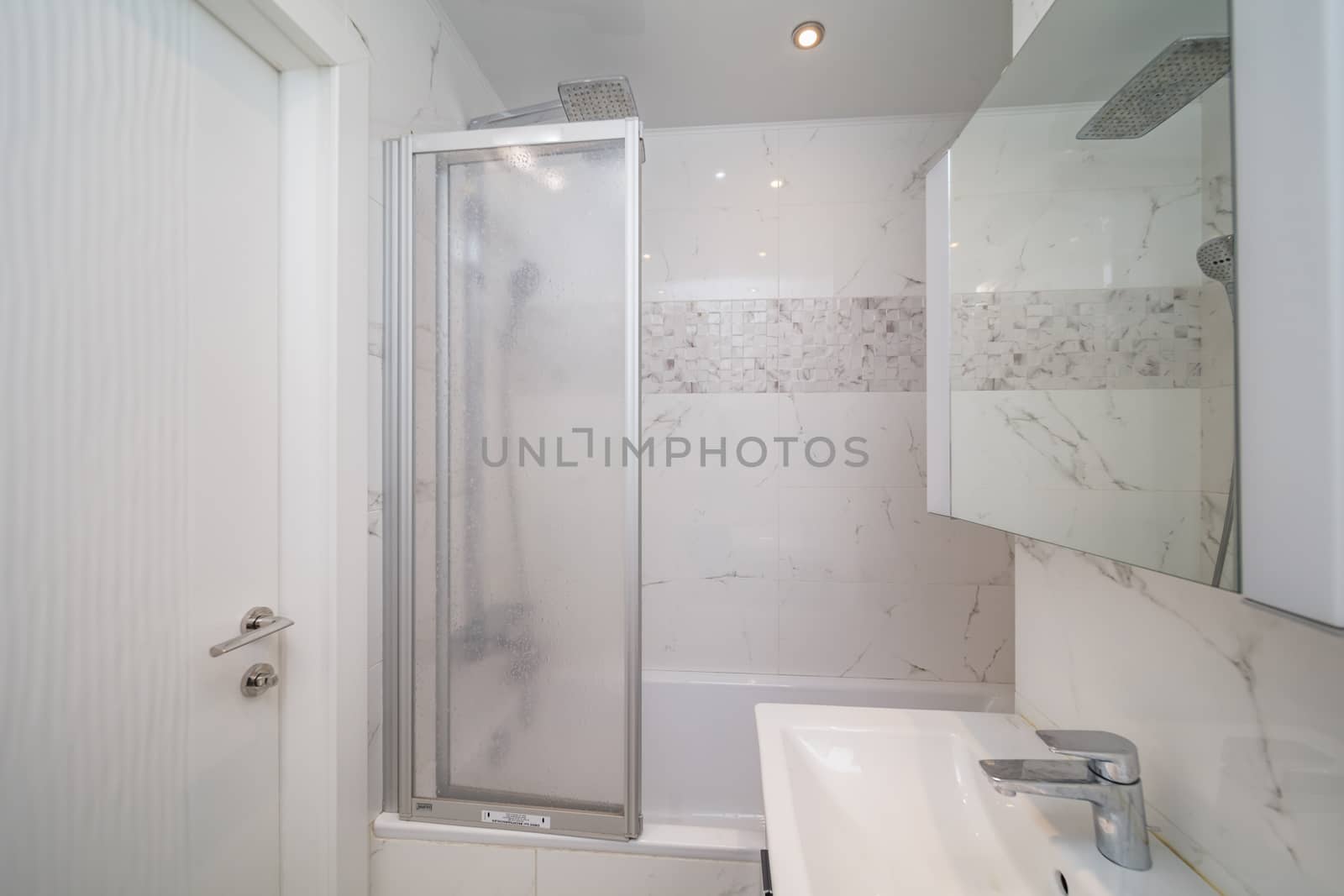 Small beige tile bathroom with bath tube and sink